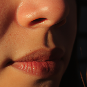 A close-up of a face with a sun-kissed glow, with soft light reflecting off the shadows of the cheeks.