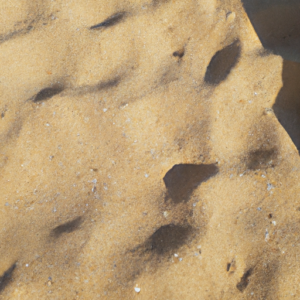 Suggested Prompt: A close-up of a beach, with a mix of sand, sun and shadows.
