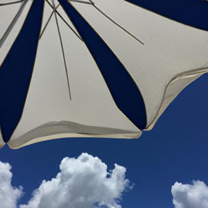 A beach umbrella with a bright blue sky and white, fluffy clouds.