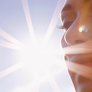 A close-up of a woman's face, with a sunburst in the background.